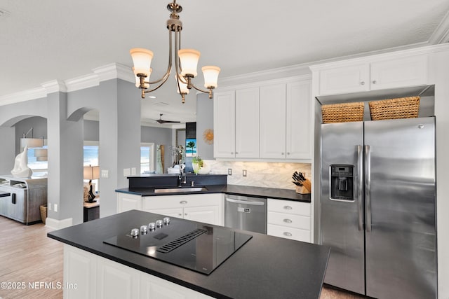 kitchen featuring stainless steel appliances, white cabinets, a chandelier, and sink