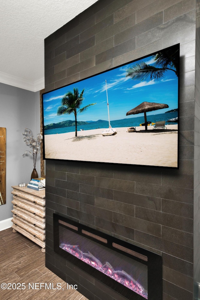 details with a textured ceiling, hardwood / wood-style floors, and crown molding