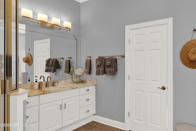 bathroom with a shower with shower door, vanity, and wood-type flooring