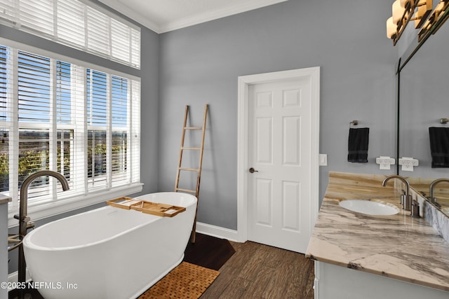 bathroom featuring a tub, crown molding, a wealth of natural light, and vanity