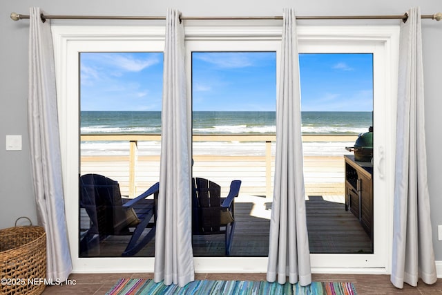 entryway featuring a wealth of natural light, a beach view, and a water view