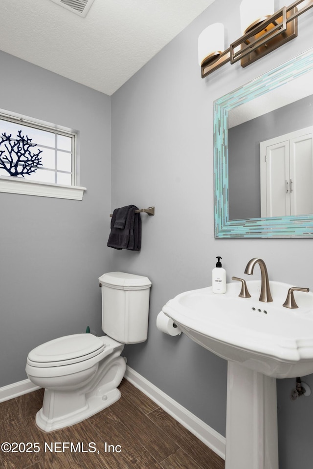 bathroom featuring sink, hardwood / wood-style floors, a textured ceiling, and toilet