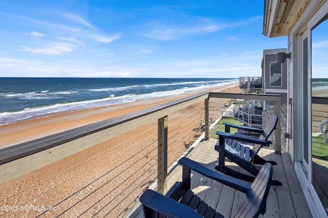 balcony featuring a water view and a view of the beach