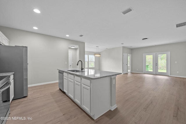 kitchen featuring a wealth of natural light, sink, a kitchen island with sink, white cabinets, and appliances with stainless steel finishes