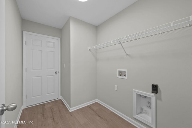 clothes washing area with hookup for an electric dryer, washer hookup, and wood-type flooring