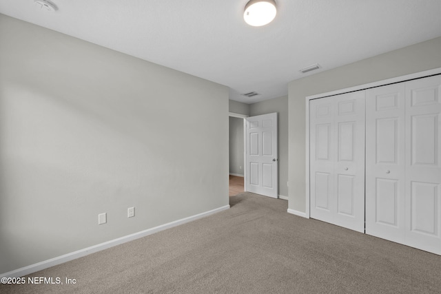 unfurnished bedroom featuring carpet flooring and a closet