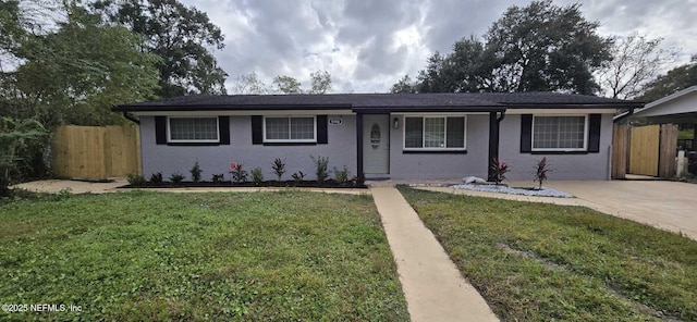 ranch-style home featuring driveway, brick siding, fence, and a front yard