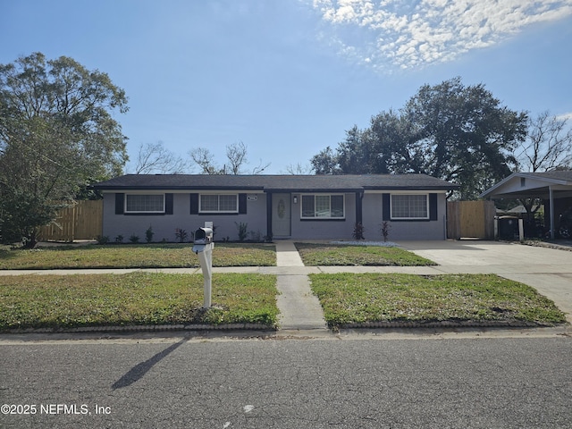 single story home featuring a carport, driveway, a front lawn, and fence