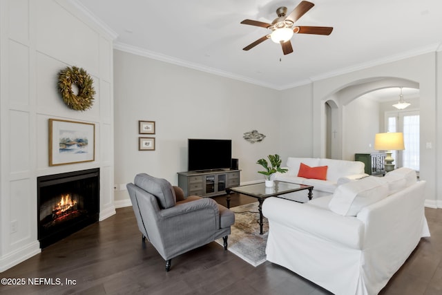 living room with crown molding, a fireplace, dark hardwood / wood-style flooring, and ceiling fan