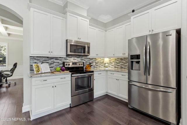 kitchen with light stone counters, dark wood-type flooring, stainless steel appliances, and white cabinets