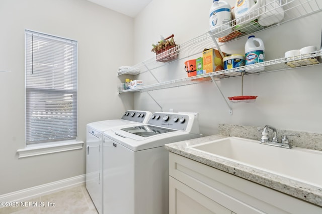 washroom with light tile patterned flooring, independent washer and dryer, and sink