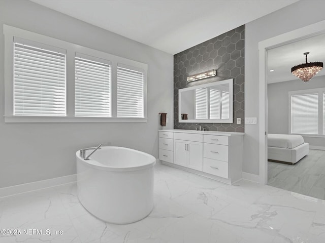 bathroom featuring decorative backsplash, vanity, a bathtub, and a notable chandelier