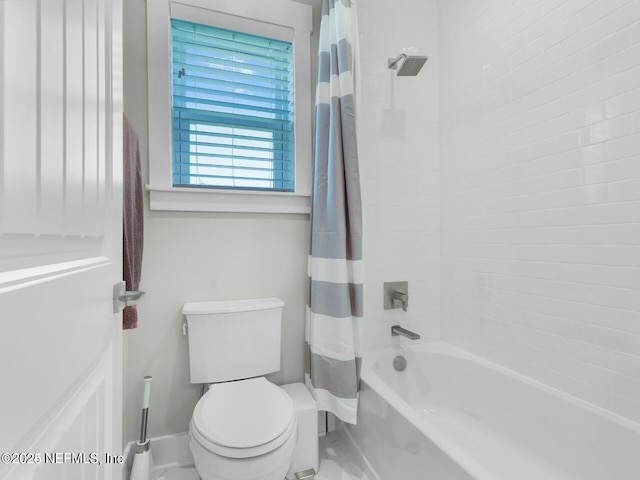 bathroom featuring shower / bathtub combination with curtain and toilet