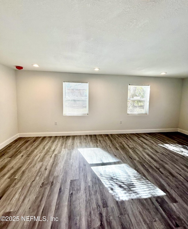 empty room with a textured ceiling and hardwood / wood-style flooring