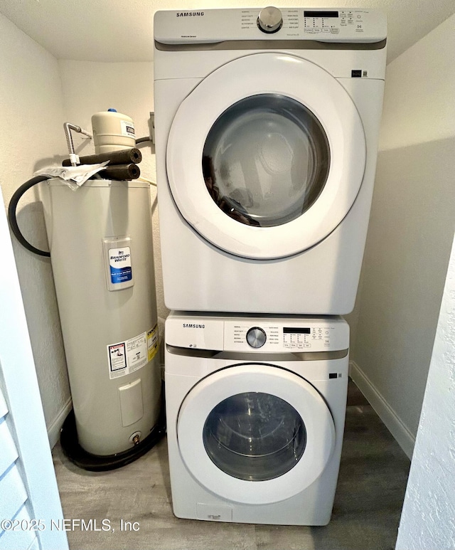 laundry area featuring hardwood / wood-style floors and stacked washer / drying machine