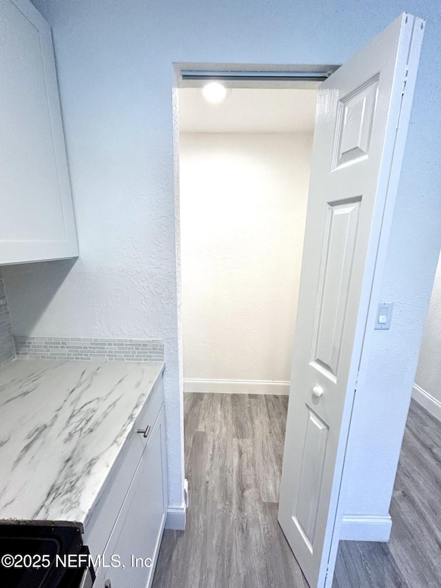 kitchen featuring light stone countertops, white cabinetry, and dark wood-type flooring