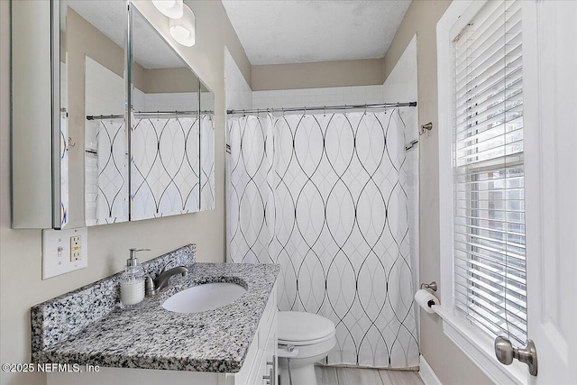 bathroom featuring walk in shower, vanity, and toilet