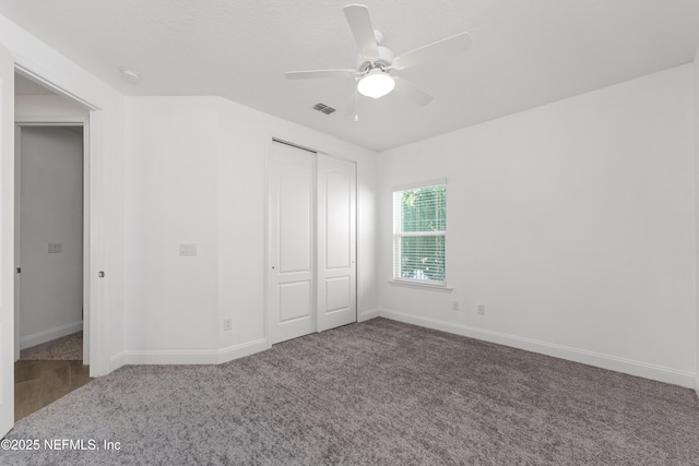 unfurnished bedroom with carpet flooring, ceiling fan, and a closet