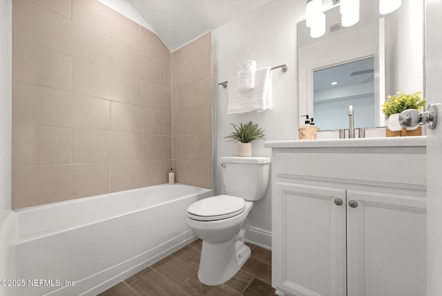 full bathroom featuring a textured ceiling, lofted ceiling, toilet, vanity, and tiled shower / bath