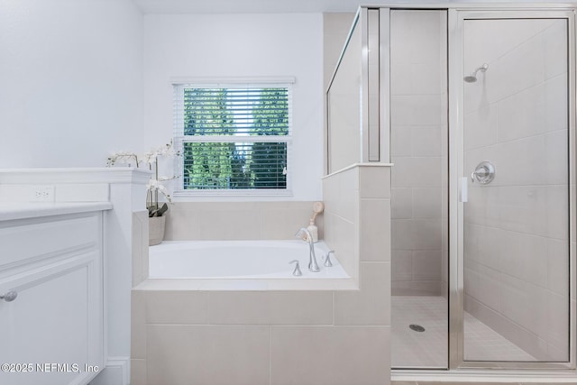 bathroom with vanity and shower with separate bathtub