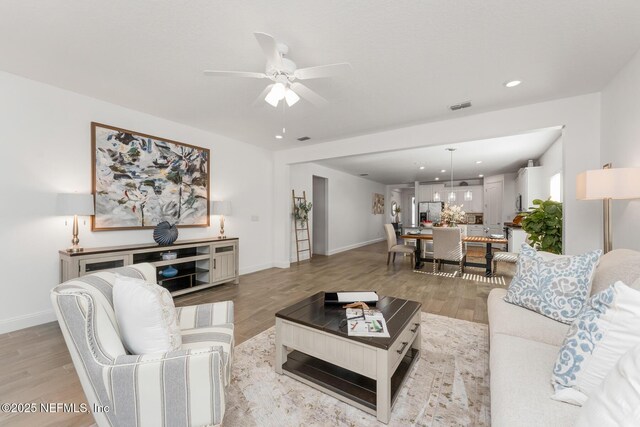 living room featuring light wood-type flooring and ceiling fan