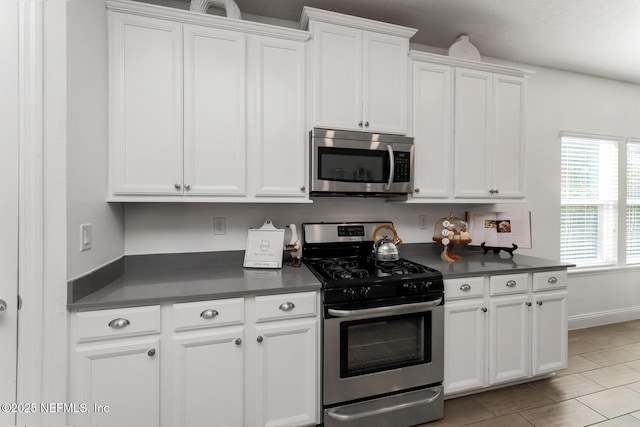 kitchen with white cabinets, appliances with stainless steel finishes, and light tile patterned flooring