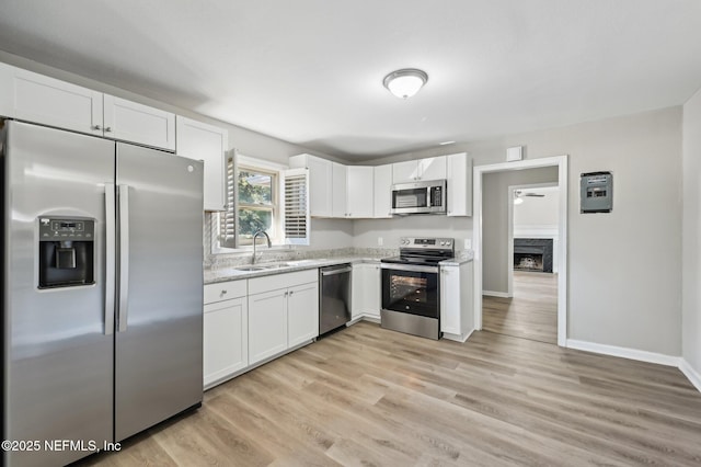 kitchen with white cabinets, light hardwood / wood-style floors, sink, and stainless steel appliances