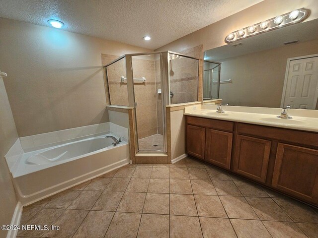 bathroom with tile patterned flooring, vanity, a textured ceiling, and shower with separate bathtub