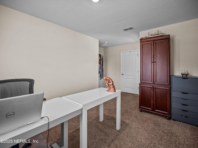 carpeted home office with a textured ceiling