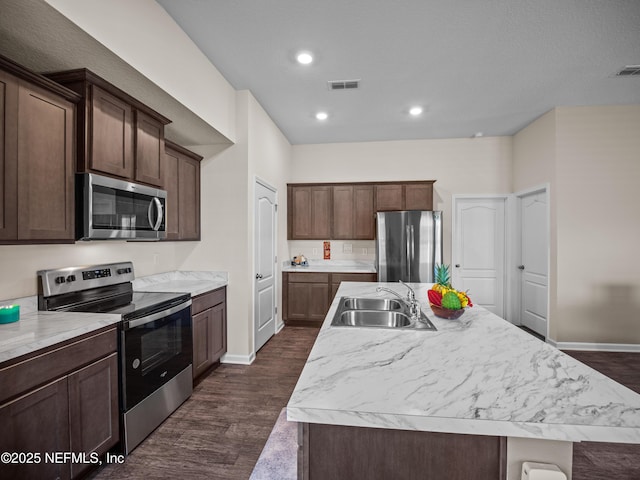 kitchen featuring a center island with sink, stainless steel appliances, dark hardwood / wood-style floors, and sink