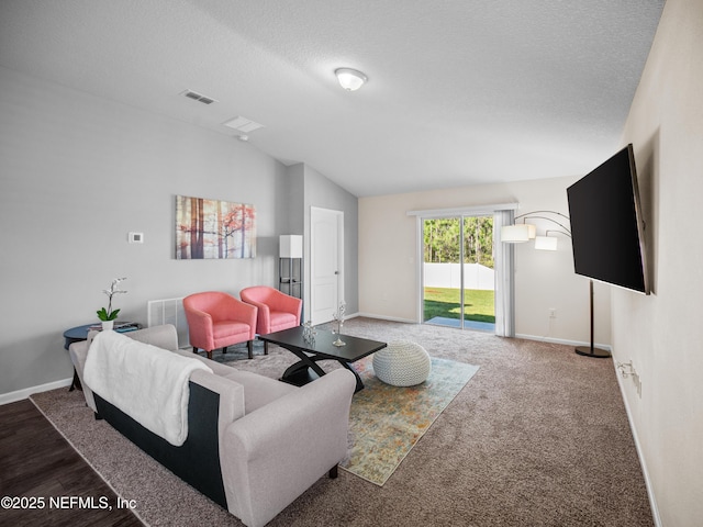 carpeted living room with a textured ceiling and vaulted ceiling