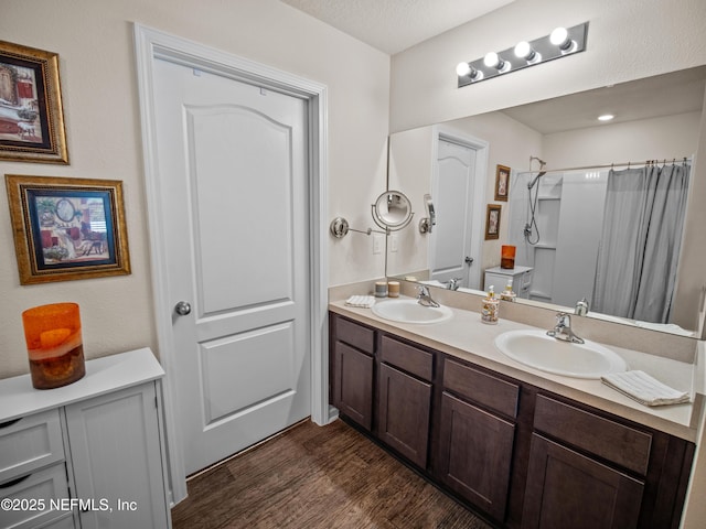 bathroom featuring vanity, hardwood / wood-style flooring, a shower with shower curtain, toilet, and a textured ceiling