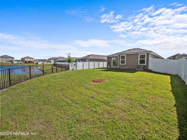 view of yard featuring central AC and a water view