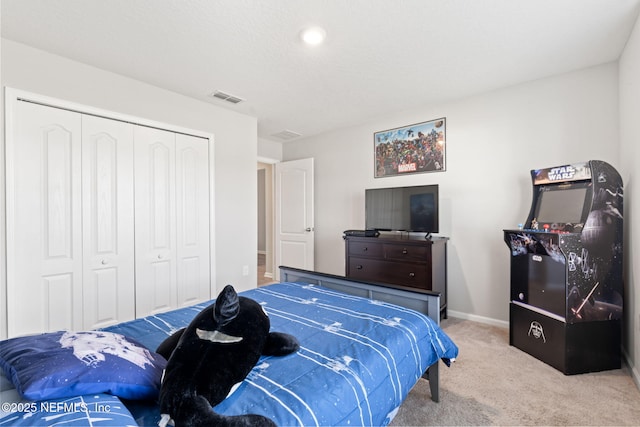 bedroom featuring light colored carpet and a closet