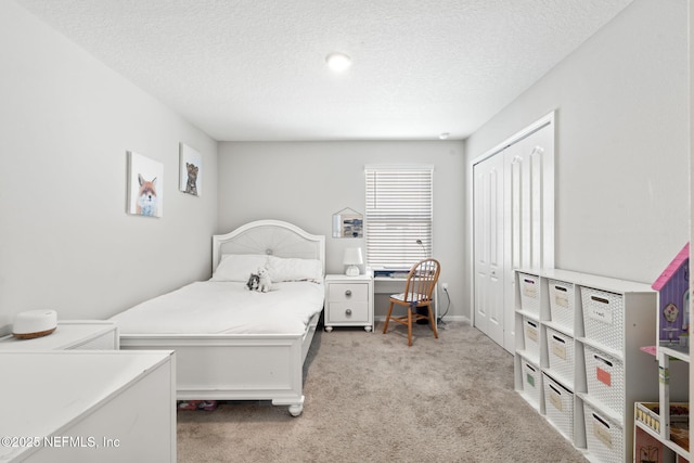 bedroom featuring light carpet, a textured ceiling, and a closet