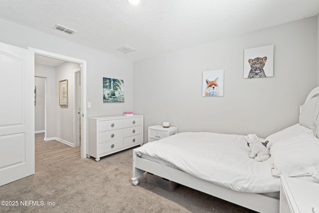 carpeted bedroom featuring a textured ceiling