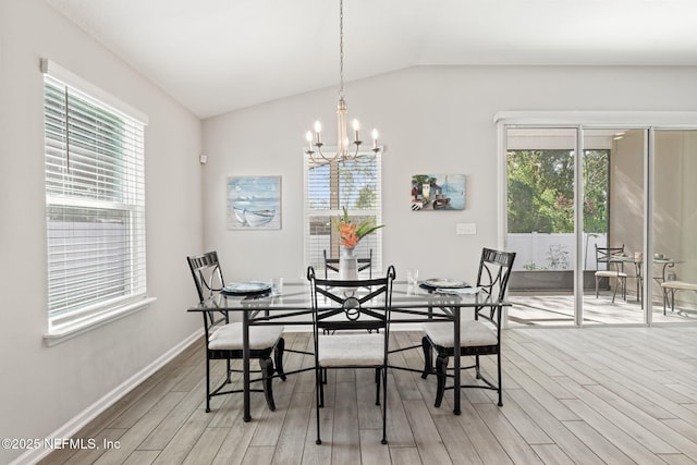 dining room featuring an inviting chandelier, vaulted ceiling, and light wood-type flooring