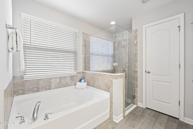 bathroom featuring separate shower and tub and hardwood / wood-style floors