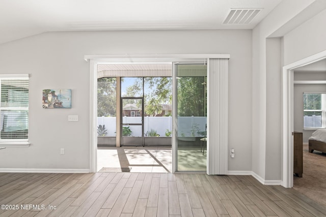 doorway to outside featuring lofted ceiling and light wood-type flooring