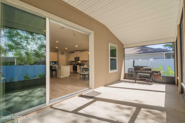 sunroom / solarium featuring vaulted ceiling