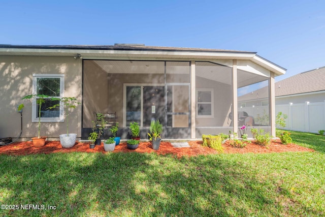 back of house with a sunroom and a yard