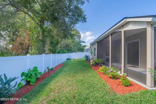 view of yard featuring central AC and a sunroom