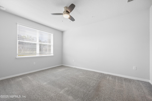 carpeted spare room with a textured ceiling and ceiling fan