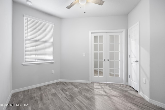 spare room featuring light hardwood / wood-style flooring, french doors, and ceiling fan