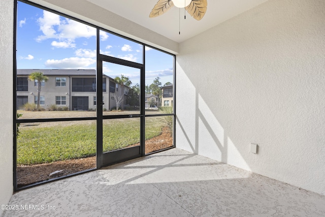 unfurnished sunroom with ceiling fan