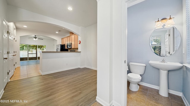 bathroom with hardwood / wood-style flooring, ceiling fan, and toilet