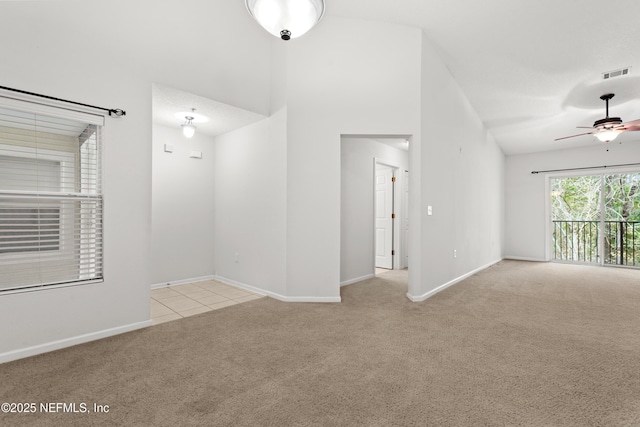 empty room featuring ceiling fan, high vaulted ceiling, carpet flooring, visible vents, and baseboards