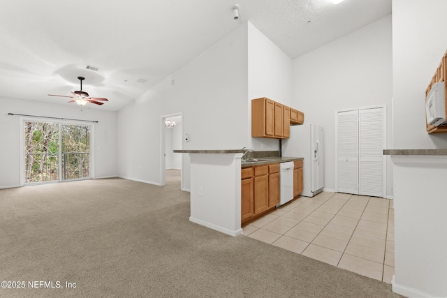 kitchen featuring light carpet, kitchen peninsula, white appliances, ceiling fan, and sink