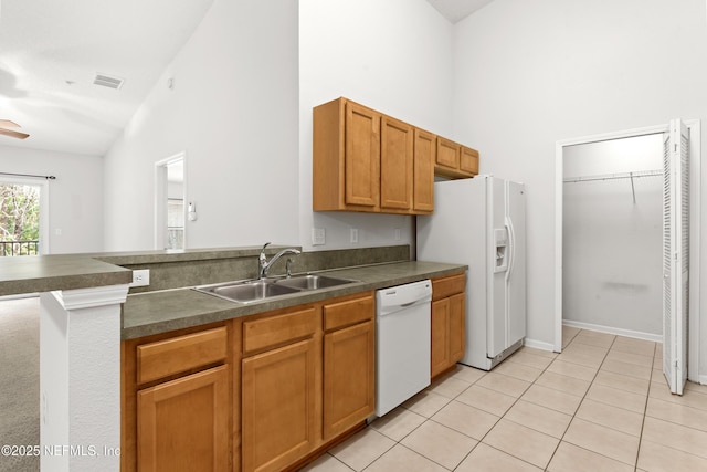 kitchen featuring light tile patterned floors, white appliances, high vaulted ceiling, and sink