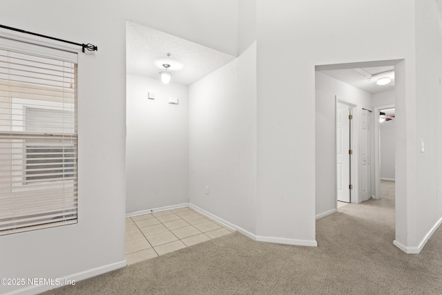 empty room with light colored carpet and a textured ceiling